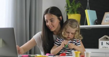 Siyah uzun saçlı laptop evde hamuru ile onun dauther açılış kutusunu çalışma çekici beyaz genç kadın. Kapalı.