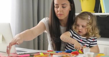 Sevimli küçük bir kız annesi onun odasına bir masada hamuru dan heykel ile sarışın kıvırcık saçlı. Kapalı.