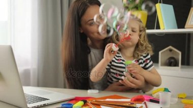 Resepsiyon odasında oturup onun anne yapma kabarcık üfleyici ile sarışın kıvırcık saçlı küçük kız. Kapalı.