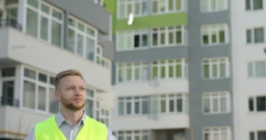 Genç Oluşturucusu'nda bir yeşil yelek ve gömlek bitmemiş inşaat arka plan üzerinde etrafa Portait. Açık.