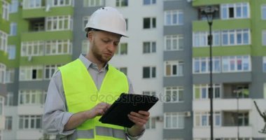 Başını ve özel kıyafetler tablet çalışmaları için kullanma koruyucu bir beyaz kask beyaz mimar. Açık.
