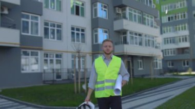 Ciddi mimar rousse saç çizimi, elinde tutan ile inşa edilmiş ev topraklarında gidiş kaskı kafasına koyarak. Açık.