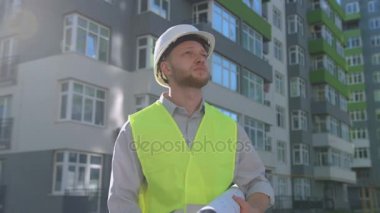 Beyaz Oluşturucusu'nda beyaz kask ve cep telefonu üzerinde konuşurken ve çizim sırasında ayakta inşa house yakınındaki arıyorum yeşil yelek.
