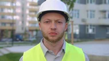 Kameraya bakarak koruyucu kask içinde sakallı ciddi beyaz Oluşturucusu portresi. Açık.