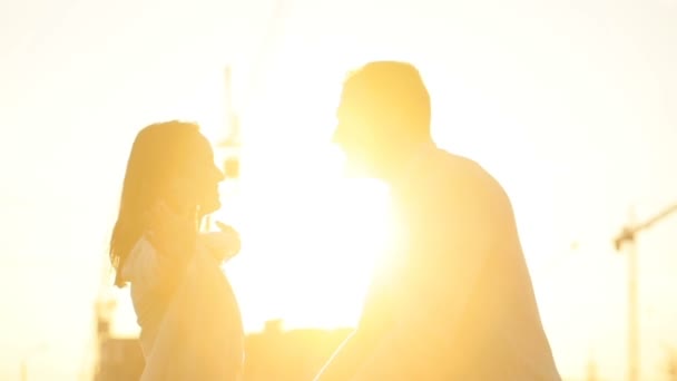 Happy νεαρό ζευγάρι με φόντο ηλιοβασίλεμα. Νεαρός αύξηση στα χέρια της νεαρής γυναίκας και χαμογελαστός. Εξωτερική. — Αρχείο Βίντεο