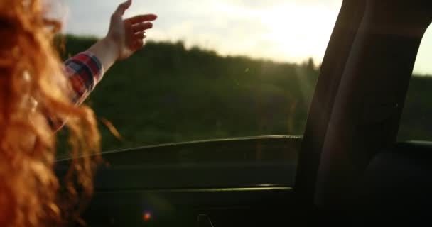 年轻的红头发幸福的女人 puttind 手通过车窗上自然背景. — 图库视频影像