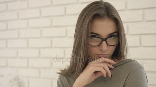 Retrato de mujer joven atractiva en el suéter desnudo con glasse possing y sonriendo en la cámara . — Vídeos de Stock