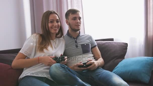 Primer plano retrato de la mujer y el hombre jugando videojuego mientras está sentado en el sofá . — Vídeos de Stock