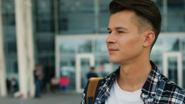 Porträtt av ung snygg man stående på modern flygplats bakgrunden. Närbild. — Stockvideo