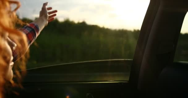 Close-up shot van het meisje dat zich uitstrekt van haar hand naar de zon. Op de weg. — Stockvideo