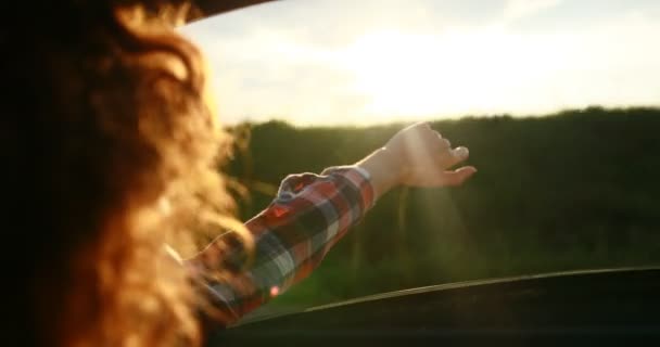 Primer plano de la chica extendiendo su mano hacia el sol. En el camino . — Vídeos de Stock