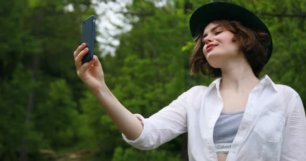Vackra unga kvinnor som använder smarta telefonen för selfie i parken — Stockvideo