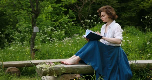 Jong meisje schrijven in haar dagboek, in het park. Vrouwen in het park schrijft in haar persoonlijke dagboek — Stockvideo
