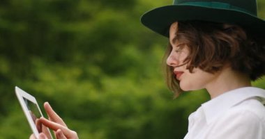 Tablet bilgisayar parkta erkek ile genç kız öğrenci yazarak bir şey touch pad, süre karşı harika manzara oturuyor