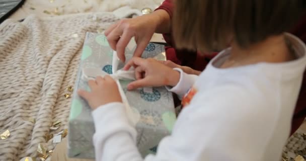 Niña abriendo caja de regalo con regalo de Navidad de su abuela. La familia intercambia regalos en Navidad. Vacaciones de Navidad y Año Nuevo . — Vídeos de Stock