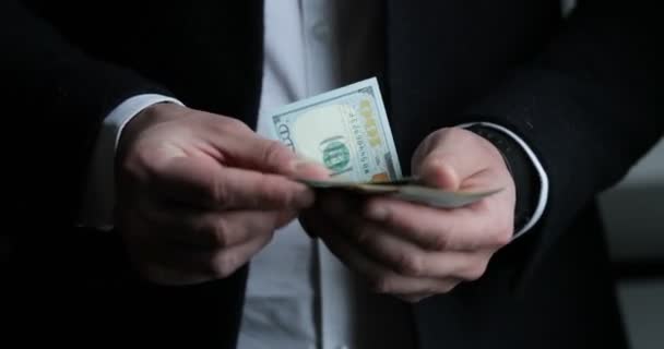 Вид человека в костюме, подсчитывающего американские счета — стоковое видео