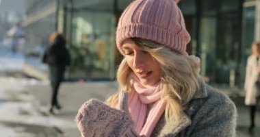 Bir kış ceket ve pembe eşarp ve kendini kış şehirde ısıtmak çalışıyor şapka giyen genç kız portresi