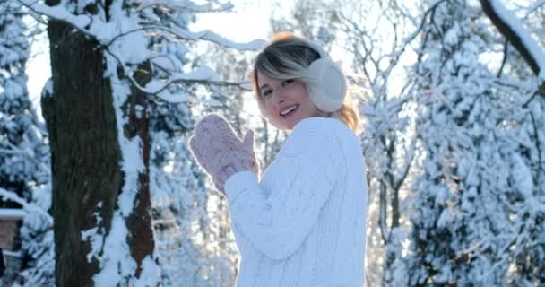 Portret van mooi blij meisje in ijzig winter park. Buitenshuis. Vliegende sneeuwvlokken, zonnige dag. verlicht. Lacht om camera, vrolijke vrolijke stemming, emoties — Stockvideo
