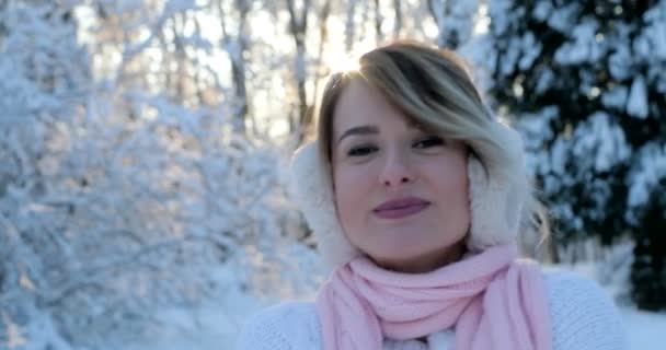 Lachende tienermeisje met oorwarmers, nemen van een selfie met smartphone buiten in de winter. Kerst, winter vakantie concept. Vrouw zwaaiende hand naar camera — Stockvideo