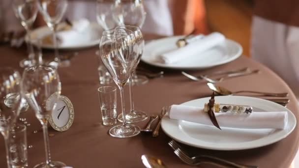 Prachtige bruiloft seveertafel. Tafel geserveerd voor de bruiloft in restoran, close-up. De stoelen en tafel voor gasten, versierd met flowes — Stockvideo