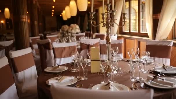 Servindo mesa de casamento requintado. Mesa servida para banquete de casamento em restoran, vista de perto. As cadeiras e mesa para os hóspedes, decorados com fluxos — Vídeo de Stock