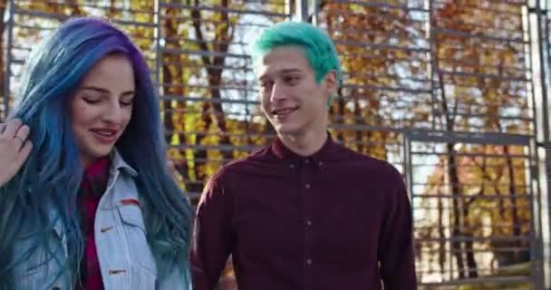 Szczęśliwi weseli biali hipsterzy, chłopak i dziewczyna, spacerujący razem jesienią po parku i rozmawiający podczas randki. Na zewnątrz. — Wideo stockowe