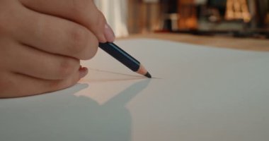 Kafkasyalı kadın eli kalem tutarken ve beyaz boş kağıda bir şeyler çizerken..
