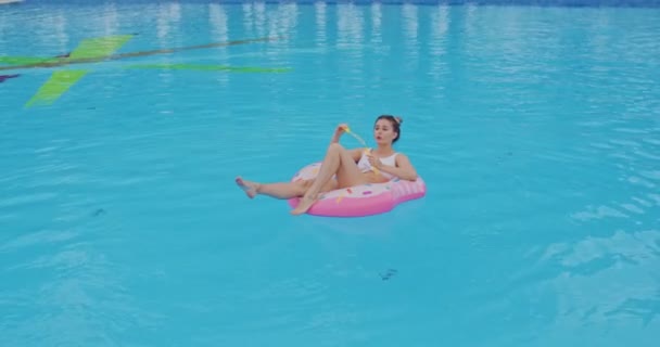 Caucásico hermosa mujer joven flotando en el flotador rosa y soplando burbujas de jabón mientras pasa tiempo con alegría en las vacaciones . — Vídeo de stock