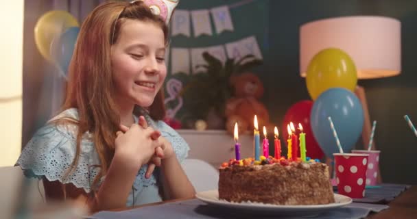 Retrato de la hermosa niña adolescente caucásica soplando velas en el pastel de cumpleaños y aplaudiendo en la fiesta . — Vídeos de Stock