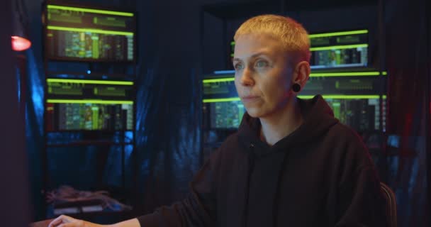 白种人妇女在夜间工作在黑暗监控室的时候通过网络黑客程序。女性匿名黑客制造电脑病毒。网络犯罪和安全概念. — 图库视频影像