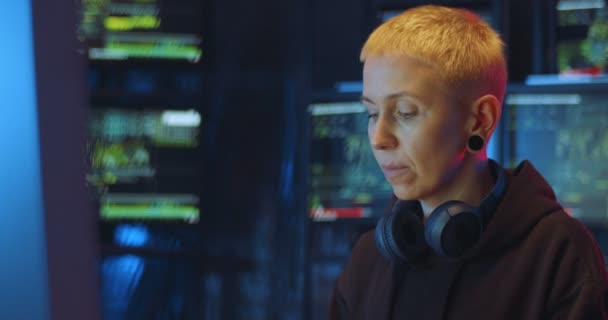 Beyaz kadın hacker veri çalarken ve monitörlerle bilgisayar başında virüs yaratırken zorlanıyor. Kadın güvenlik sistemini hackliyor ve şebekeyi kırıyor. — Stok video