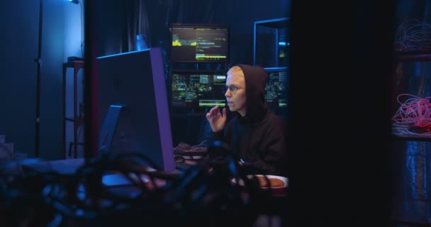 Kaukázusi nő Szemüveges munkás, aki éjszaka a programon dolgozik, sötét szobában, sok monitorral. Női cyber-rendőrnő, aki számítógépes antivírust készít. Számítástechnikai bűnözés és biztonság. — Stock videók