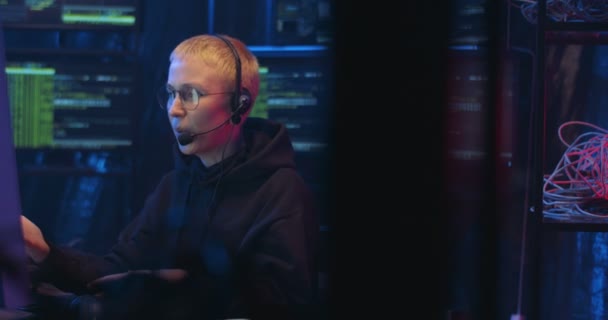 Caucasian female professional IT worker in headset typing on keyboard, working on computer and talking as having call. Woman from cybersecurity police in call center speaking in mic. — Stock Video