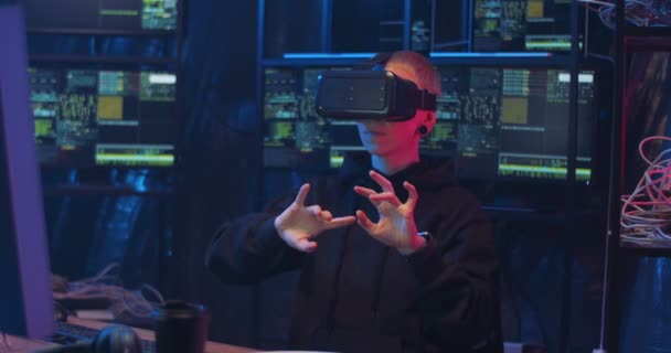 Blanke vrouwelijke cyberpolitieagent in Vr bril zittend in donkere monitoringkamer met computerschermen en met virtuele headset. Vrouw hacker tikken en scrollen in de lucht. Cyber reality wereld. — Stockvideo