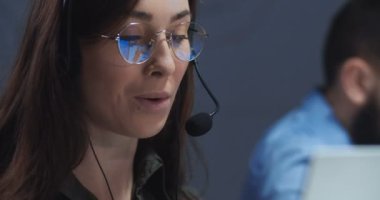 Çağrı merkezinde dizüstü bilgisayarda çalışan güzel beyaz bir bayanı yakından çek. Çağrı merkezinde internet kamerası aracılığıyla müşteriyle konuşan bir kız. Kadın ofis çalışanı video kasette sohbet ediyor..