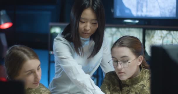 Mujer joven asiática mostrando algo a dos mujeres soldados caucásicas y educándolas en el control de la oficina del ejército. Centro militar educativo para el concepto de la mujer . — Vídeos de Stock