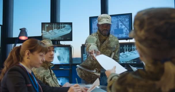 African American young military male general handing documents to Caucasian army staff at meeting. Conference on army studing and planning. Brainstorming of naval strategy. Troops studying. — Stock Video