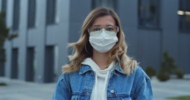 Dışarıya bakan maske takan ve koruyucu gözlüklü kadın portresi. Sağlık ve güvenlik, N1H1 koronavirüs, virüs koruma ve tıbbi konsept. Sokaktaki tıbbi maskeli genç kız..