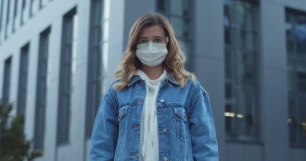 Portret van een vrouw met een bril, beschermend medisch masker met stopbord op straat. Gezondheid, veiligheid, N1H1 coronavirus, virusbescherming, medisch concept. Thuis blijven, quarantaine. — Stockvideo