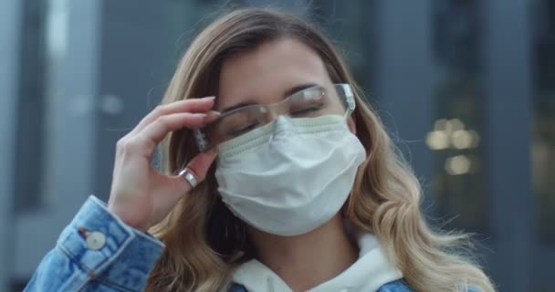 Ung kvinna tar av sig medicinsk mask. Andas djupt och ler tittar på kameran. isolerad på vit bakgrund. Sjukvård och medicinskt koncept. Stanna hemma, karantän — Stockvideo