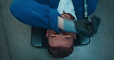 Beyaz tenli, yorgun ve kirli adam araba mühendisinin otomobilin altından çıkan tekerlekler ve alnından ter silmesi. Erkek tamirciye yukarıdan bak. Mekanik iş kavramı.