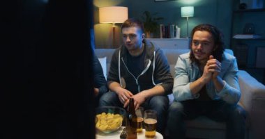 Beyaz, mutlu, dost canlısı adamlar akşamları evde kanepede televizyon izleyip futbol maçında favori takım için tezahürat yapıyorlar. Erkek hayranlar gece televizyon ekranının önünde dinleniyorlar..