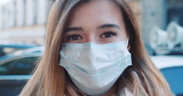 Gros plan portrait d'une jeune étudiante portant un masque de protection dans la rue à côté d'une voiture de police à haut-parleur. Concept de vie en santé et sécurité, coronavirus, protection contre les virus, pandémie — Video