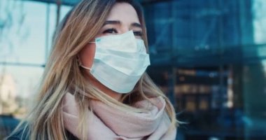 Koruyucu maske takarak boş sokaklarda yürüyen bir kadın tıbbi personelin portresi. Sağlık ve güvenlik kavramını, koronavirüs karantinasını, virüs korumasını