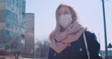 Coronavirus covid 19 'u önlemek için yüz koruma maskesi takan beyaz kadın portresi. Karantinada halka açık alanda yürüyen bir kadın..