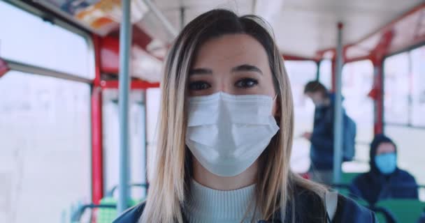 Ritratto di giovane donna bionda in maschera medica e guanti che cammina con mezzi pubblici vuoti. Concetto salute e sicurezza, quarantena coronavirus, protezione dal virus — Video Stock