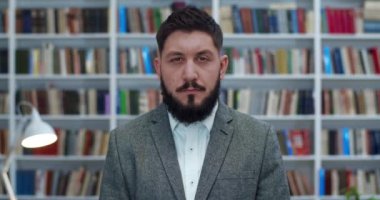 Kafkasyalı yakışıklı bir adamın portresi arafta dikilip kameraya bakıyor. Bibliyotheca 'da sakallı genç bir profesör ya da erkek öğrencinin yorgun ve mutsuz yüzünü kapatın. Kitaplarla dolu bir odada araştırmacı..