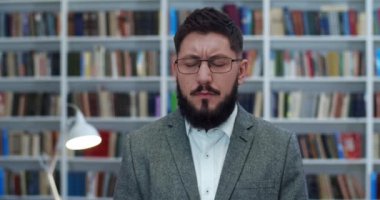 Kütüphanede dikilmiş misanderstand gibi duran, gözlüklü, beyaz, öfkeli genç bir adamın portresi. Erkek, hayır der gibi başını sallıyor ve reddediyor. Bibliyotheca 'da profesör. Kitapçının müşterisi..
