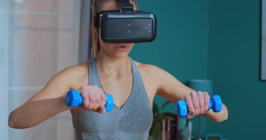 Evde VR gözlükleriyle egzersiz yapan atletik kadın portresi. Sanal gerçekliğe bağlı sanal gerçeklik gözlüğü takan bir kadın kişisel eğitmen. Spor ve spor. Eğitim, egzersiz ve sağlık konsepti.