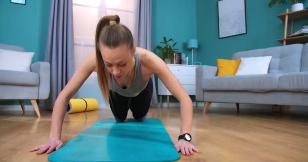 Passa och tona upp kvinnan gör fitness träning och press ups övningar för hälsosam livsstil och starka händer i vardagsrummet hemma. Friska och sport livsstil. Träning, träning och wellness koncept. — Stockvideo